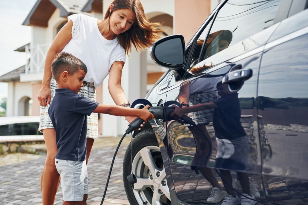 Family plugging in their electric vehicle at home in Austin