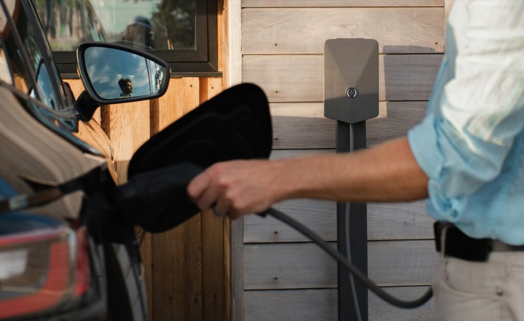 Homeowner using a wall-mounted EV charger in Leander